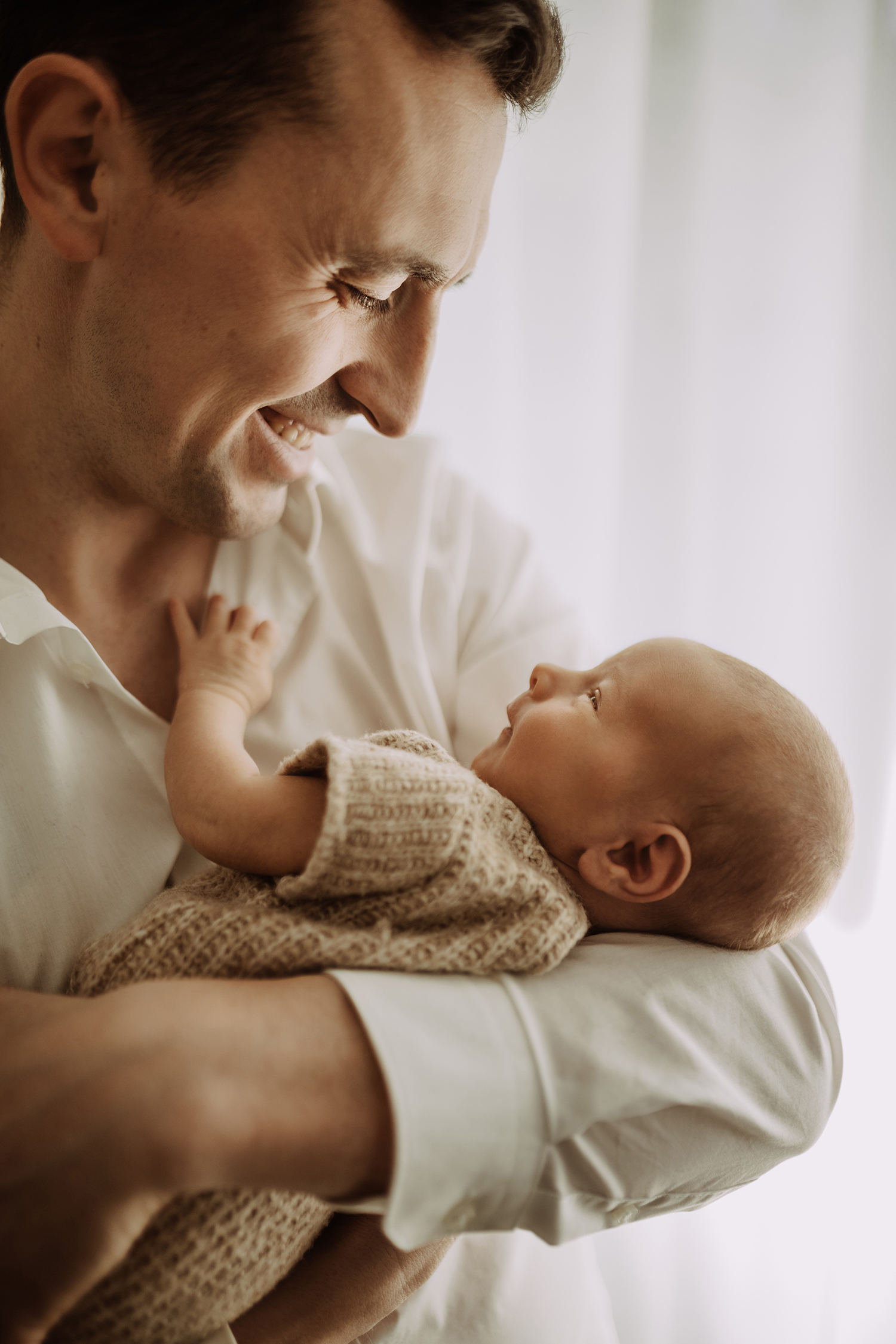 Papa mit neugeborenem Sohn auf dem Arm